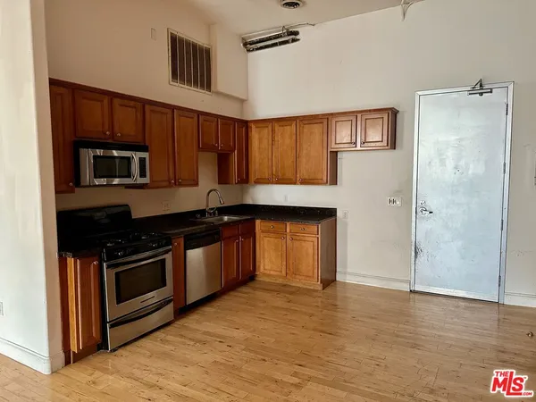 a kitchen with granite countertop a stove and a refrigerator