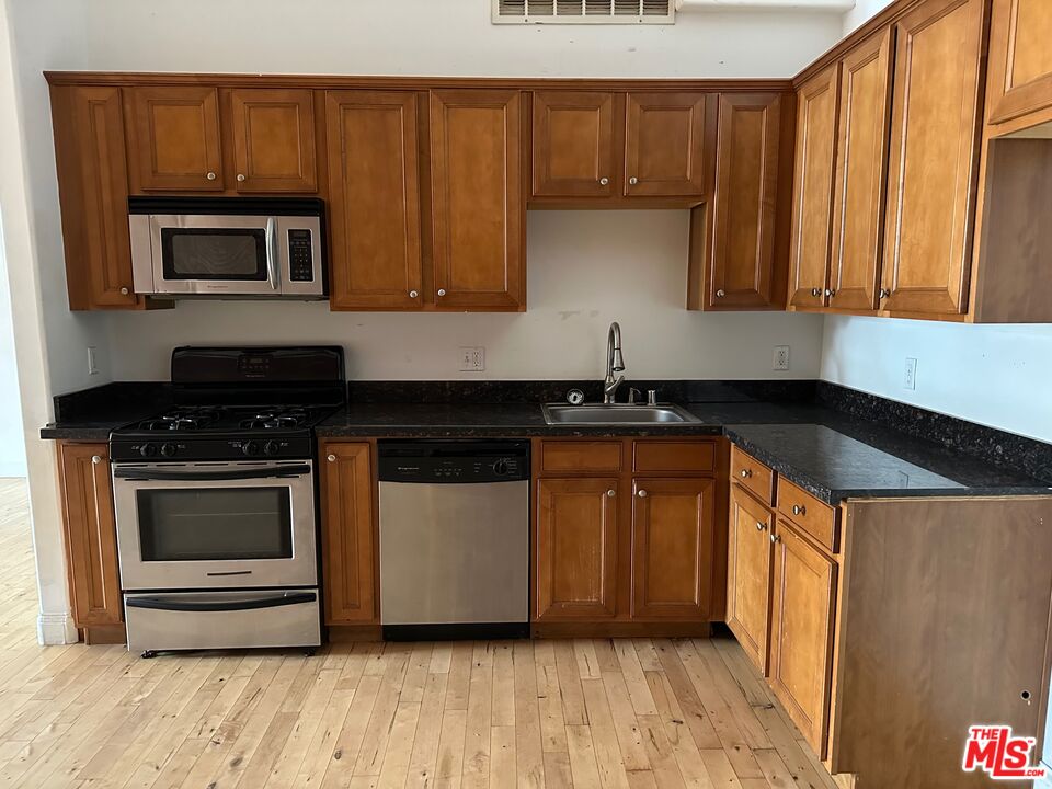 726 South Santa Fe Avenue, Unit 202 Los Angeles, CA 90021 - Photo 7 of 9 a kitchen with stainless steel appliances a stove a microwave and a sink