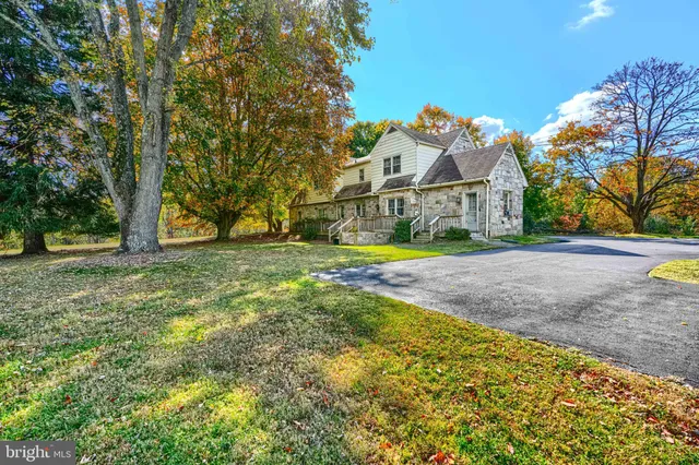 a view of residential houses with yard and green space
