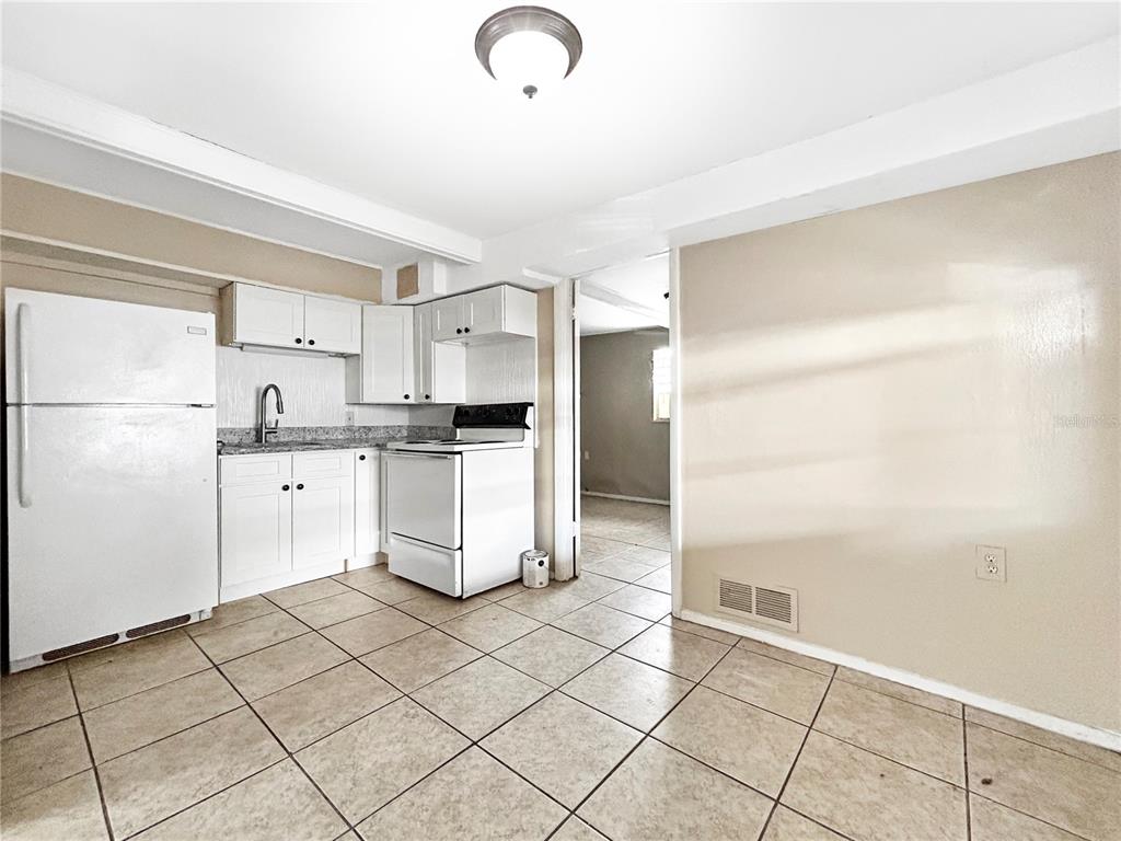 6308 20th Street Zephyrhills, FL 33542 - Photo 13 of 19 a kitchen with white cabinets and white appliances