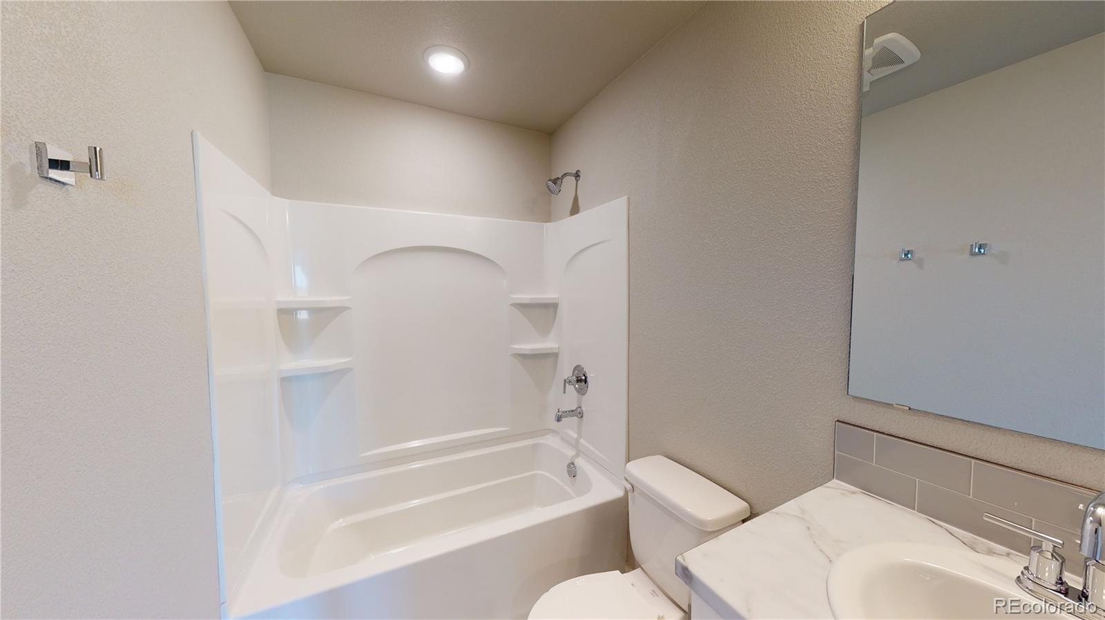 1353 Reynolds Street, Unit 9B Fort Lupton, CO 80621 - Photo 13 of 14 a bathroom with a bathtub and a toilet