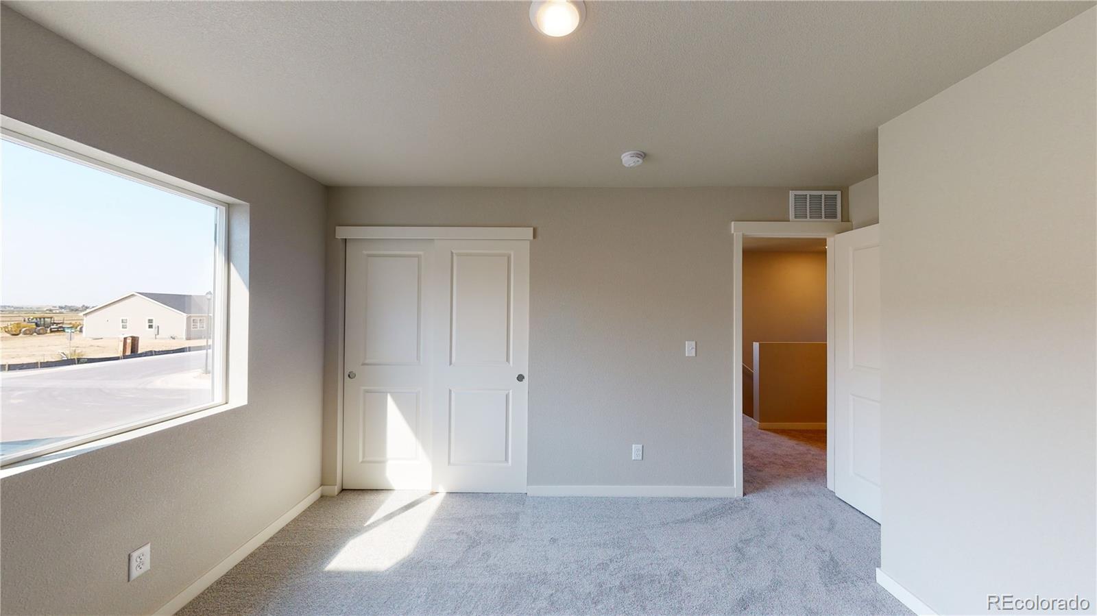 1353 Reynolds Street, Unit 9B Fort Lupton, CO 80621 - Photo 14 of 14 wooden floor in an empty room with a window