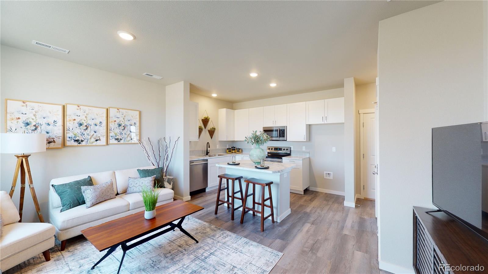 1353 Reynolds Street, Unit 9B Fort Lupton, CO 80621 - Photo 4 of 14 a living room with stainless steel appliances furniture and a flat screen tv