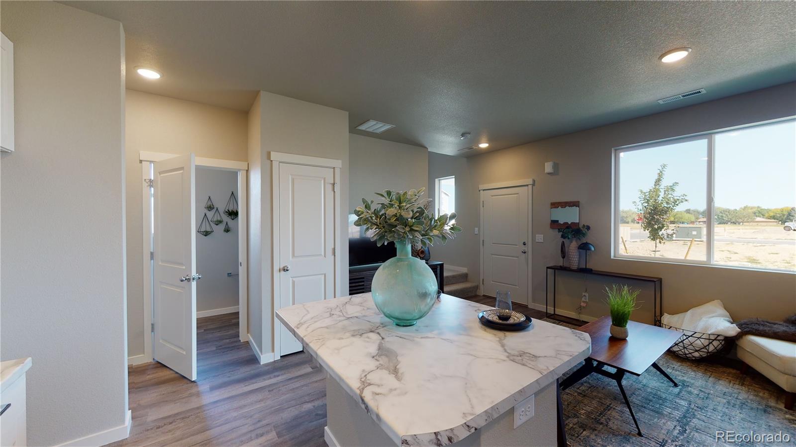 1353 Reynolds Street, Unit 9B Fort Lupton, CO 80621 - Photo 7 of 14 a view of a dining room with furniture window and wooden floor