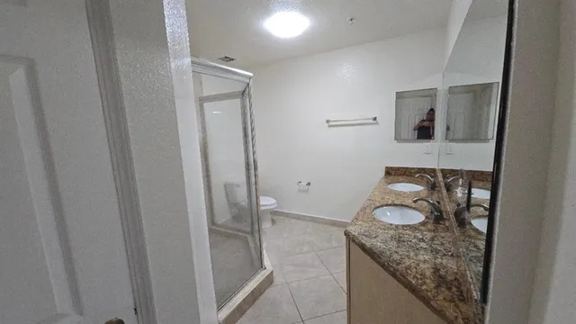 a bathroom with a granite countertop sink and a toilet