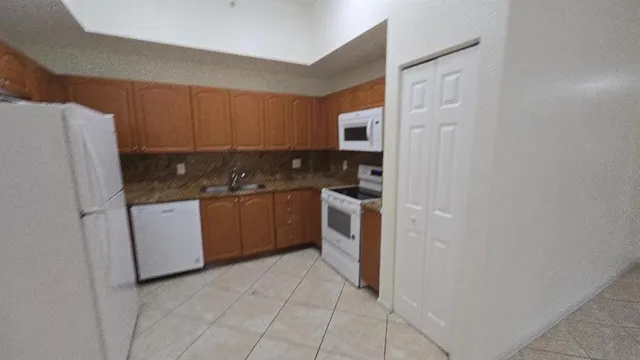 a kitchen with a sink a refrigerator and cabinets