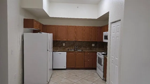 a kitchen with stainless steel appliances granite countertop a refrigerator and a stove