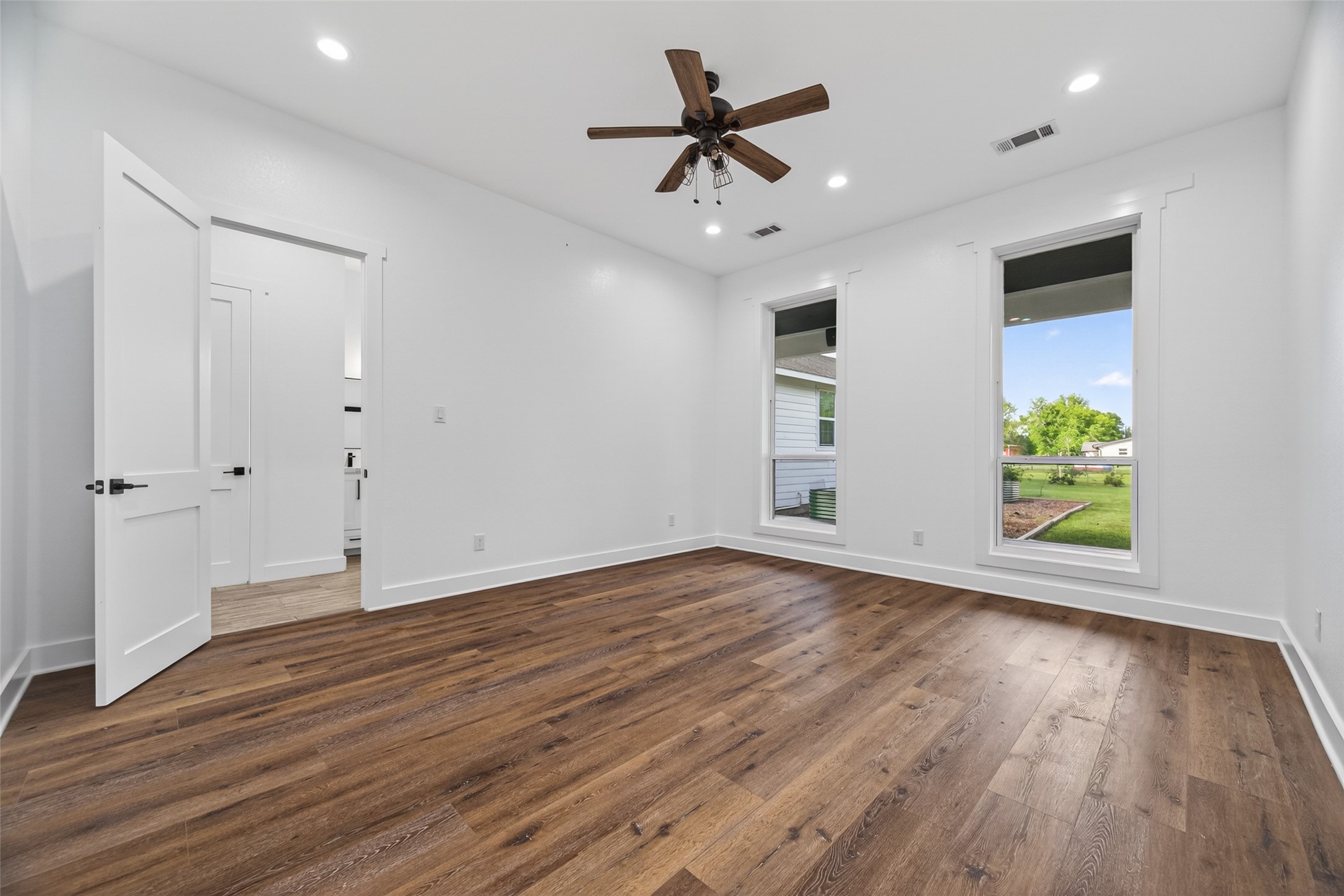 12625 Padon Road Needville, TX 77461 - Photo 18 of 50 Spacious bedroom with clean modern lines, recessed lighting, and wide-plank flooring—offering a versatile layout for comfort and style.