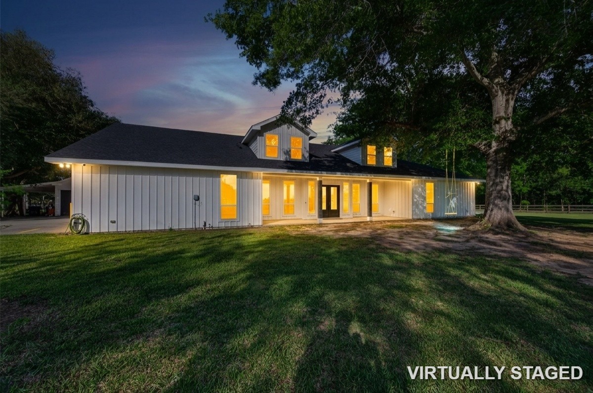12625 Padon Road Needville, TX 77461 - Photo 2 of 50 Stunning twilight view of the home showcasing warm interior lighting, expansive outdoor space, and peaceful country setting.