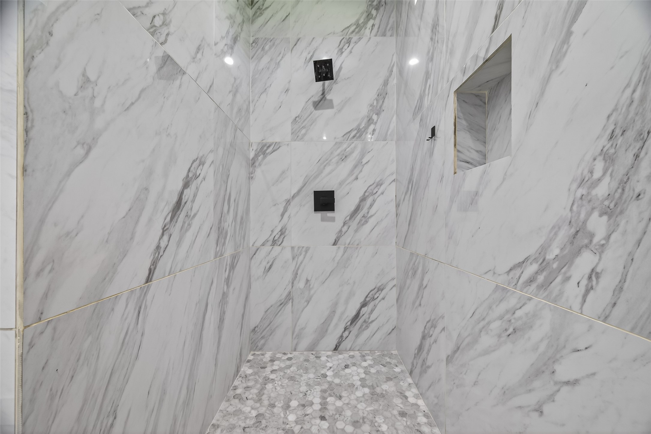12625 Padon Road Needville, TX 77461 - Photo 22 of 50 Spa-like walk-in shower with elegant floor-to-ceiling tile, modern fixtures, and built-in niche for a sleek, luxurious feel.