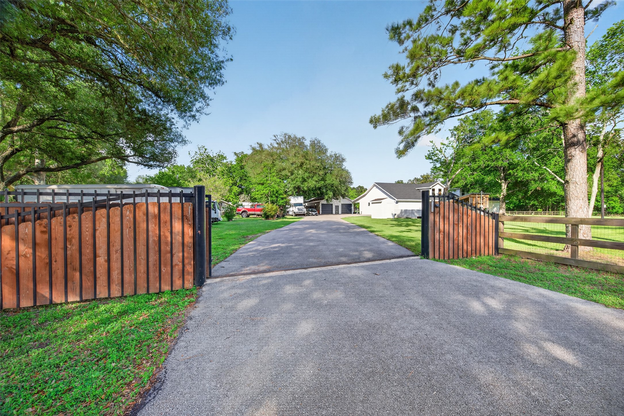 12625 Padon Road Needville, TX 77461 - Photo 40 of 50 Private gated entry with remote access opens to a long asphalt driveway, offering ample parking and a secure, welcoming arrival.