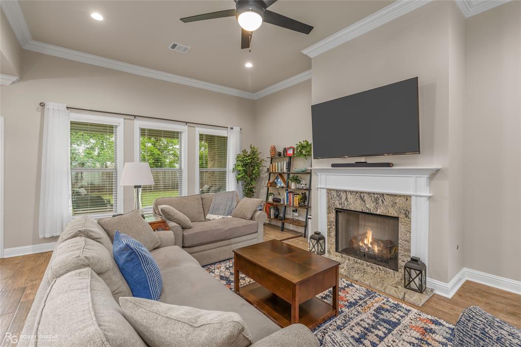 122 Brimestone Loop Benton, LA 71006 - Photo 9 of 33 a living room with furniture a flat screen tv and a fireplace