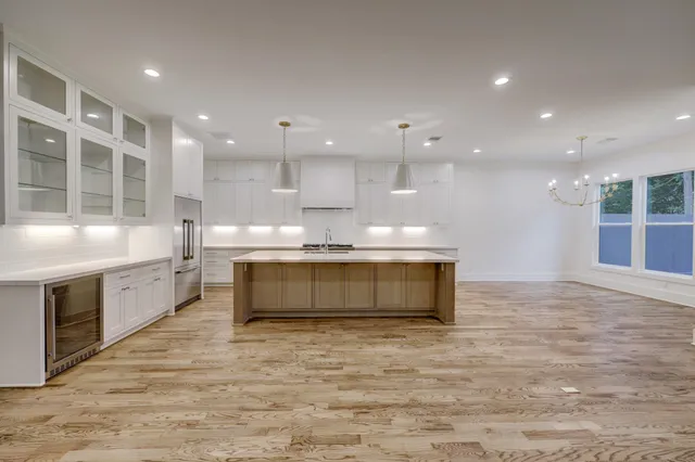 a large kitchen with kitchen island a sink stainless steel appliances and cabinets
