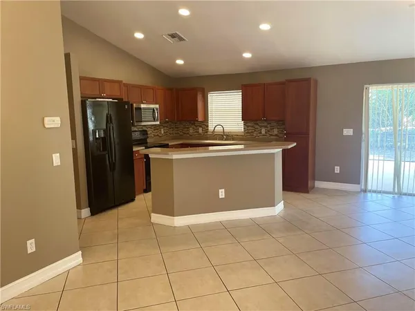 a view or kitchen with stainless steel appliances granite countertop a refrigerator and a sink