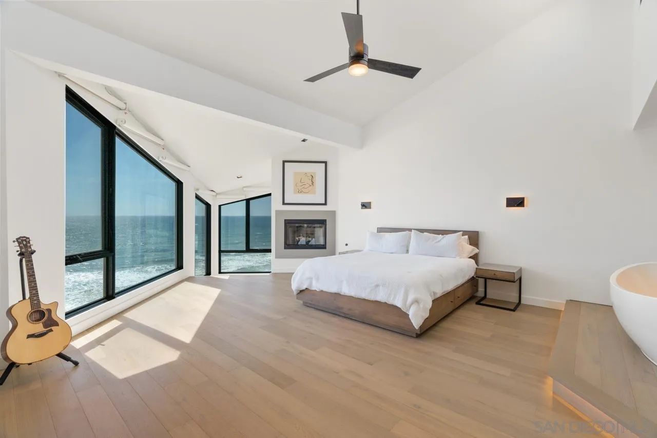 135 South Sierra Avenue, Unit 32 Solana Beach, CA 92075 - Photo 13 of 27 a spacious bedroom with a large bed and a chandelier fan