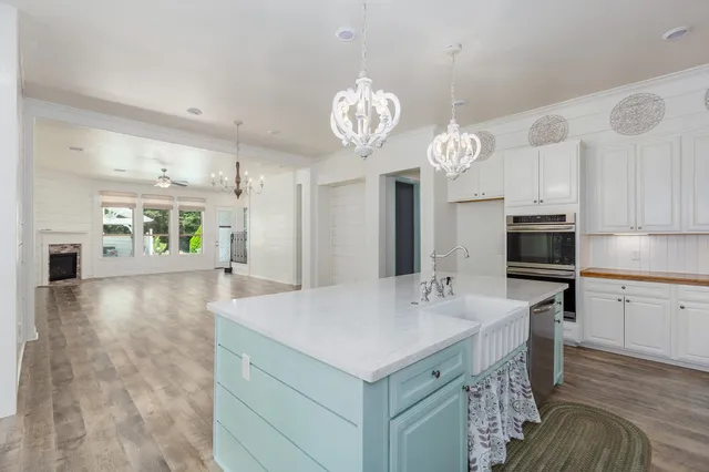 a very nice looking dining room with kitchen island a chandelier