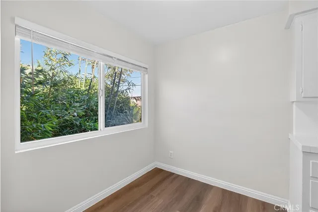 a view of a small space with wooden floor and a window