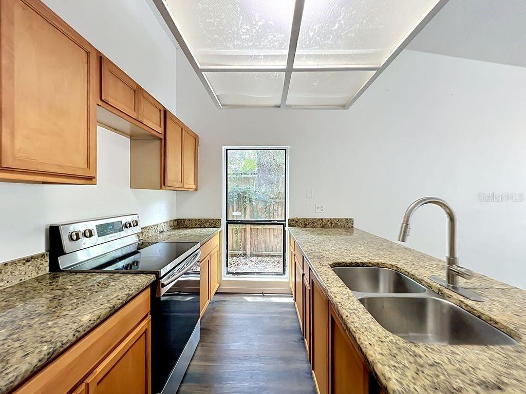 5214 2nd Street Orlando, FL 32810 - Photo 12 of 50 a kitchen with granite countertop a sink a counter space appliances and cabinets