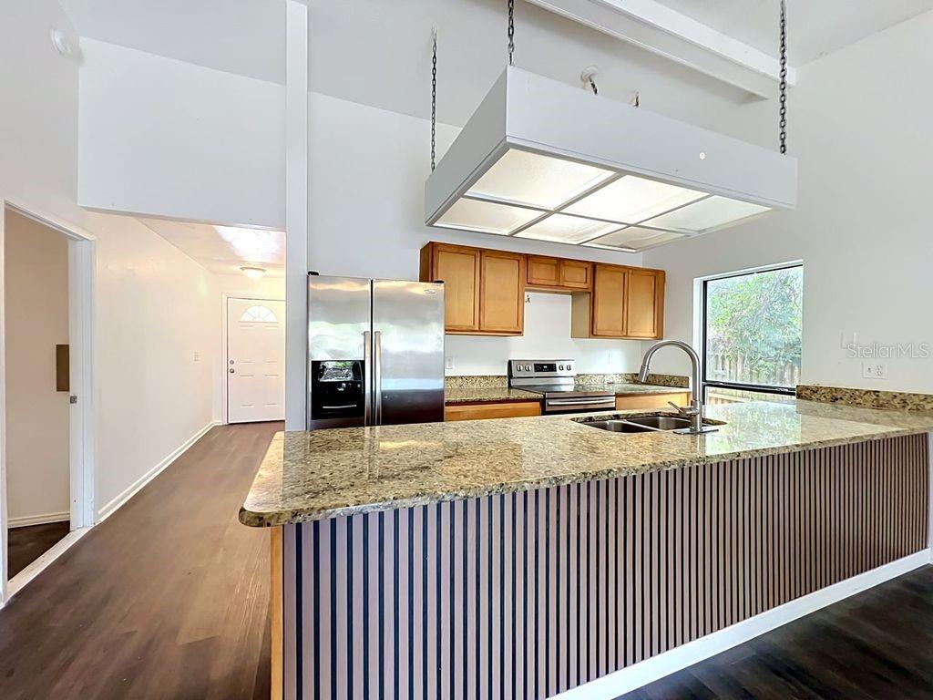 5214 2nd Street Orlando, FL 32810 - Photo 18 of 50 a kitchen with stainless steel appliances granite countertop a sink stove and wooden cabinets