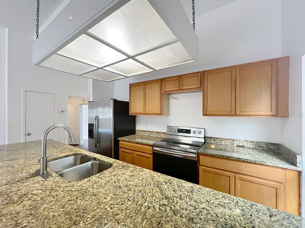 5214 2nd Street Orlando, FL 32810 - Photo 19 of 50 a kitchen with granite countertop a sink stainless steel appliances and cabinets