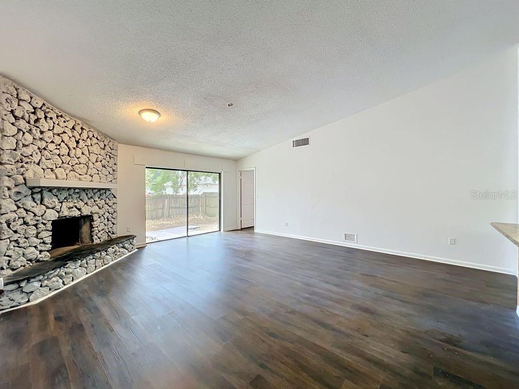 5214 2nd Street Orlando, FL 32810 - Photo 22 of 50 an empty room with wooden floor fireplace and windows