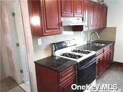 a kitchen with granite countertop a stove top oven sink and cabinets
