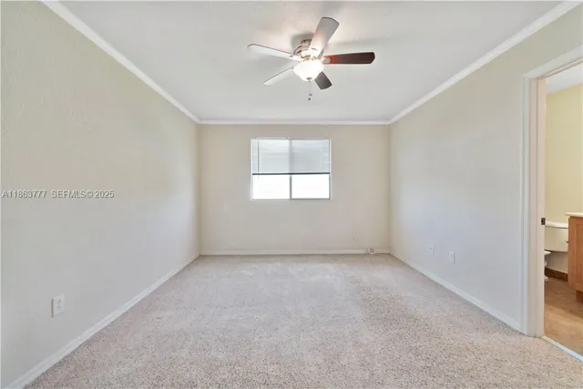 an empty room with windows and ceiling fan