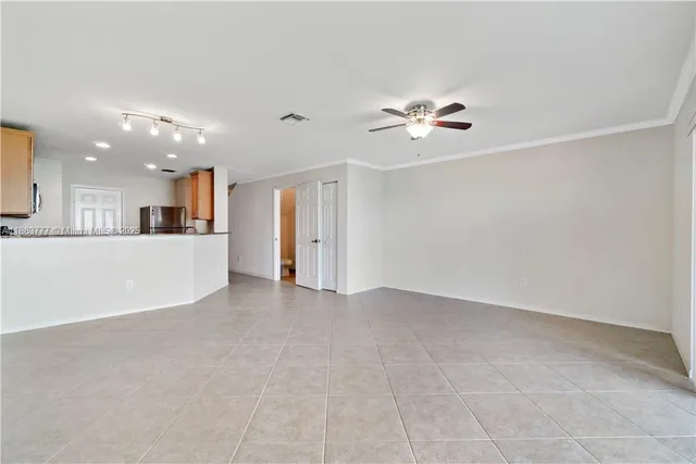 an empty room with a view of a kitchen