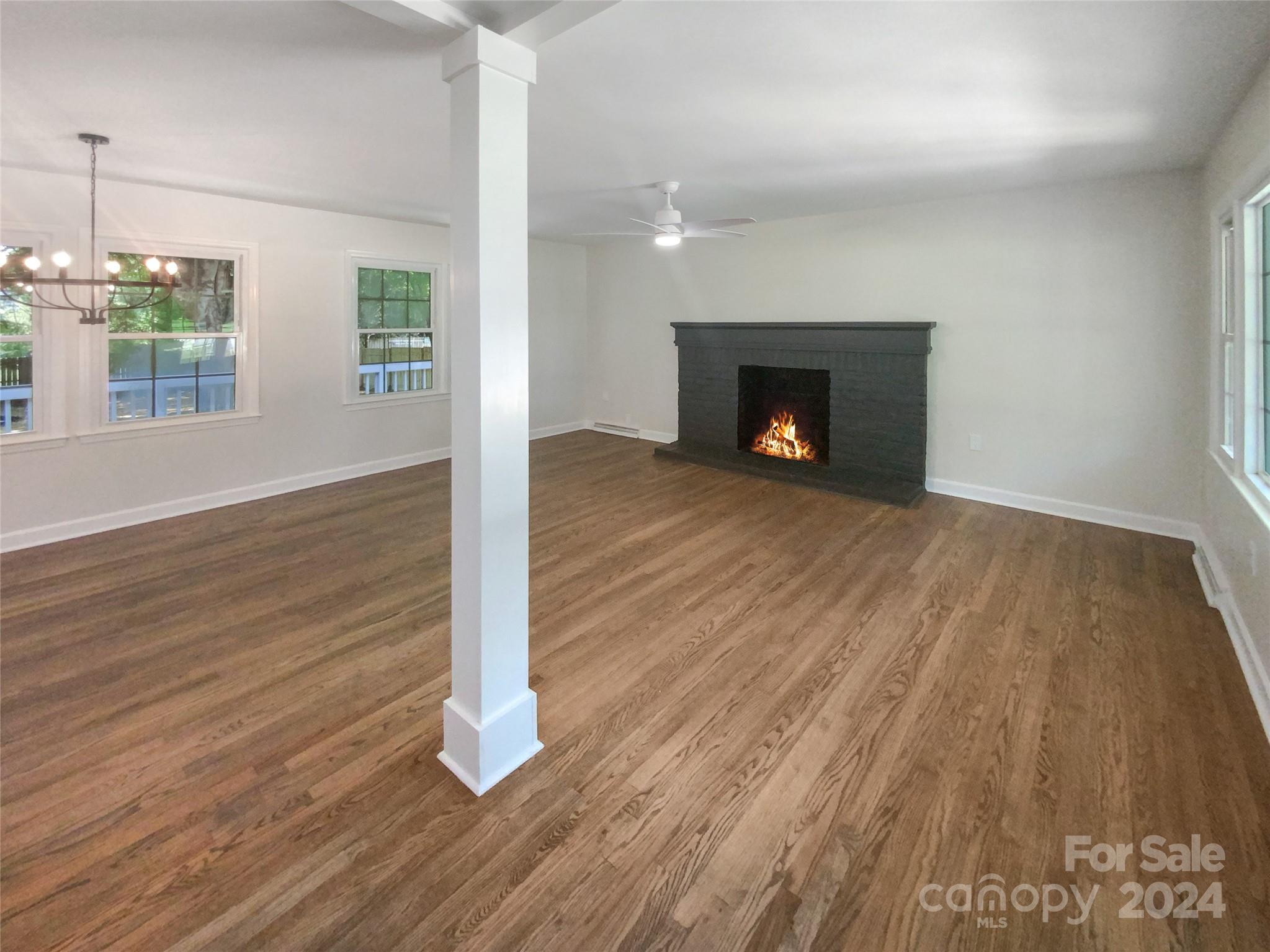 1110 Radio Road Statesville, NC 28677 - Photo 3 of 21 an empty room with wooden floor a fireplace and windows