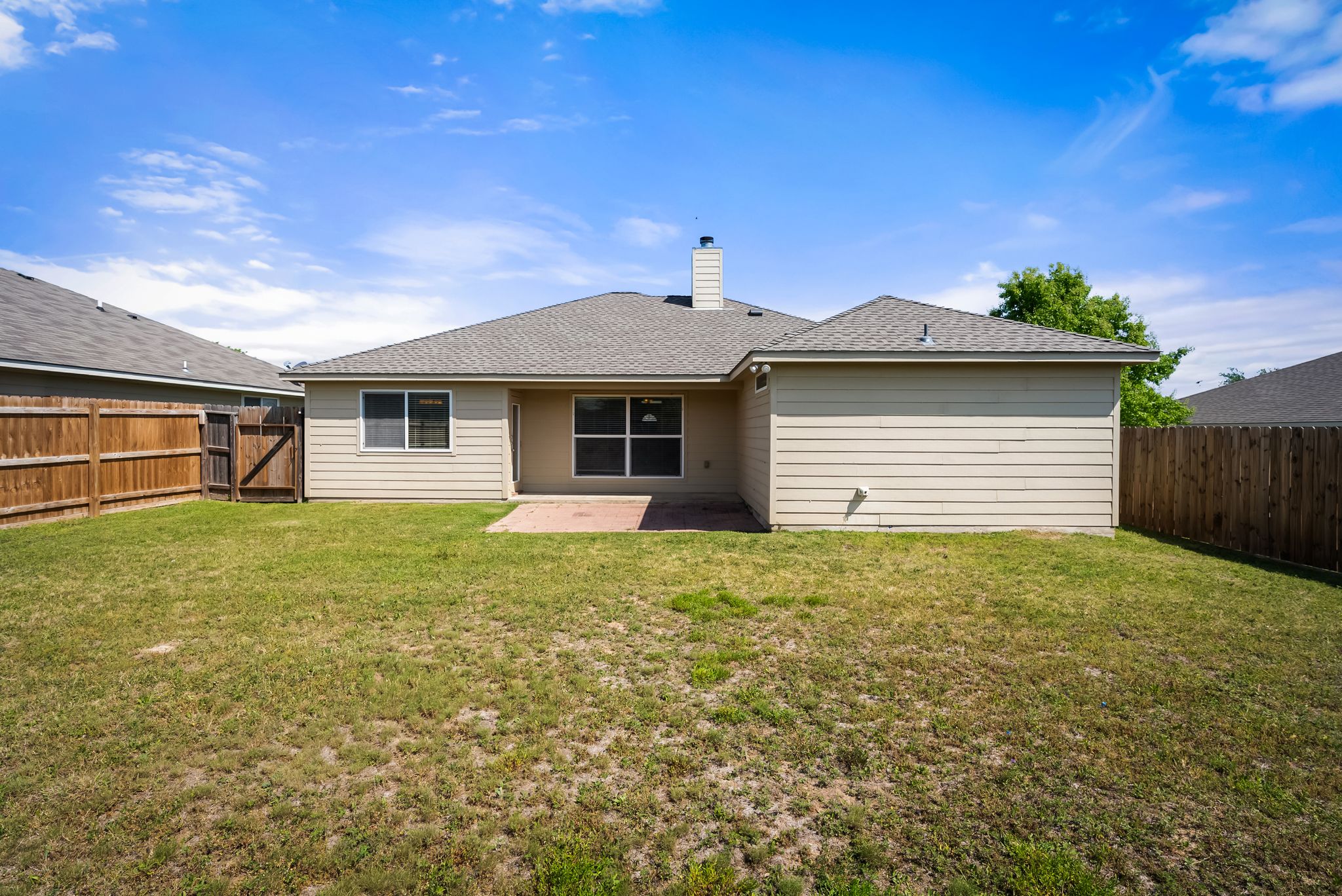7719 Fieldstone Drive Temple, TX 76502 - Photo 29 of 37 Back of property with a patio, a shingled roof, a fenced backyard, and a chimney