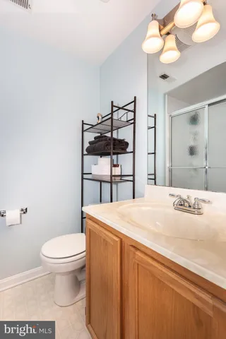 a bathroom with a granite countertop sink a toilet and a mirror