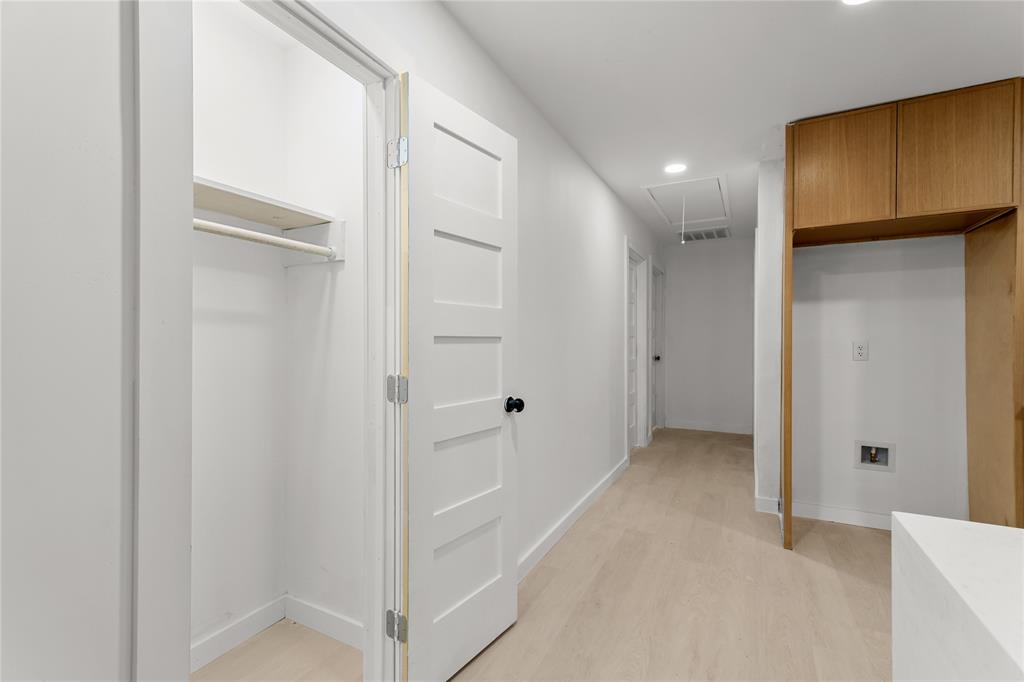 110 Hackberry Street Lancaster, TX 75146 - Photo 21 of 32 Hallway featuring light wood-finish flooring, recessed lighting, a built-in closet with shelving and hanging rod, and a utility area with wood cabinetry