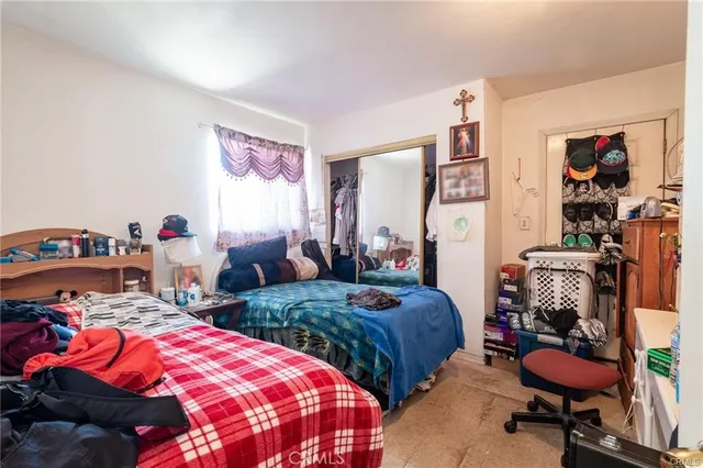 a bedroom with two beds and a closet