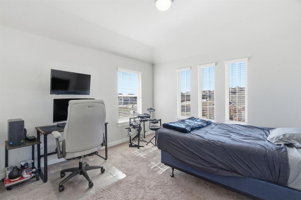 5613 Smt Crk Road Fort Worth, TX 76126 - Photo 29 of 40 a bedroom with a bed a chair and a chandelier