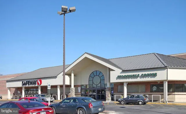 a front view of a building with parking space and a car parked