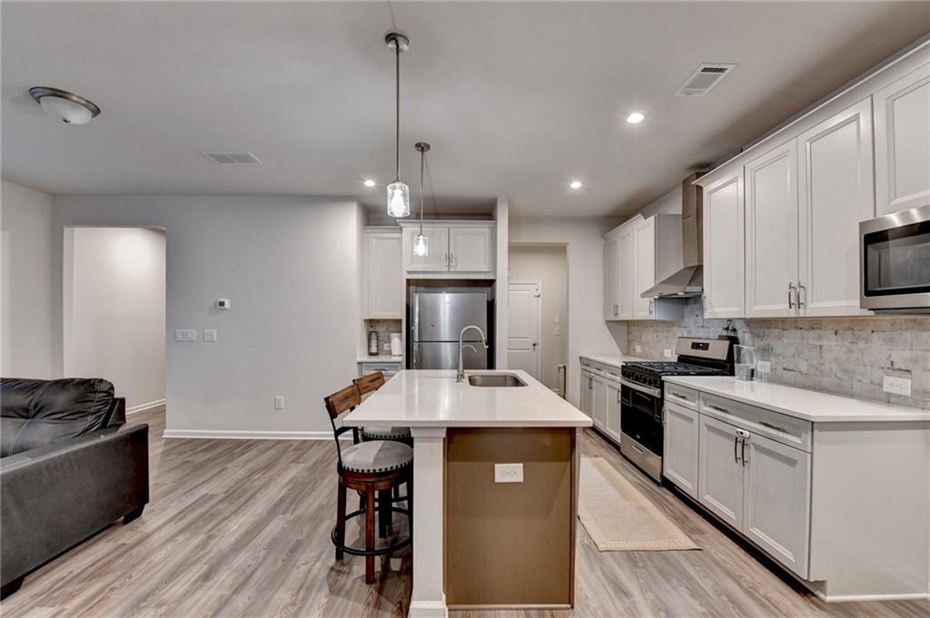 682 Smokey Quartz Way Kennesaw, GA 30144 - Photo 16 of 49 a kitchen with kitchen island granite countertop a sink a counter top space appliances and cabinets