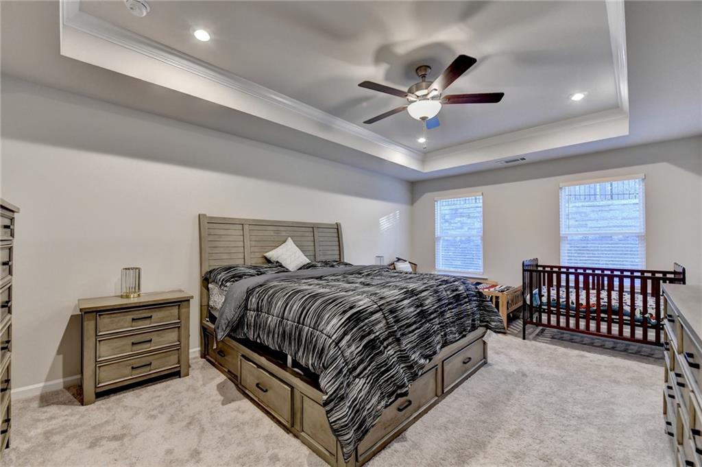 682 Smokey Quartz Way Kennesaw, GA 30144 - Photo 26 of 49 a bedroom with a bed and ceiling fan