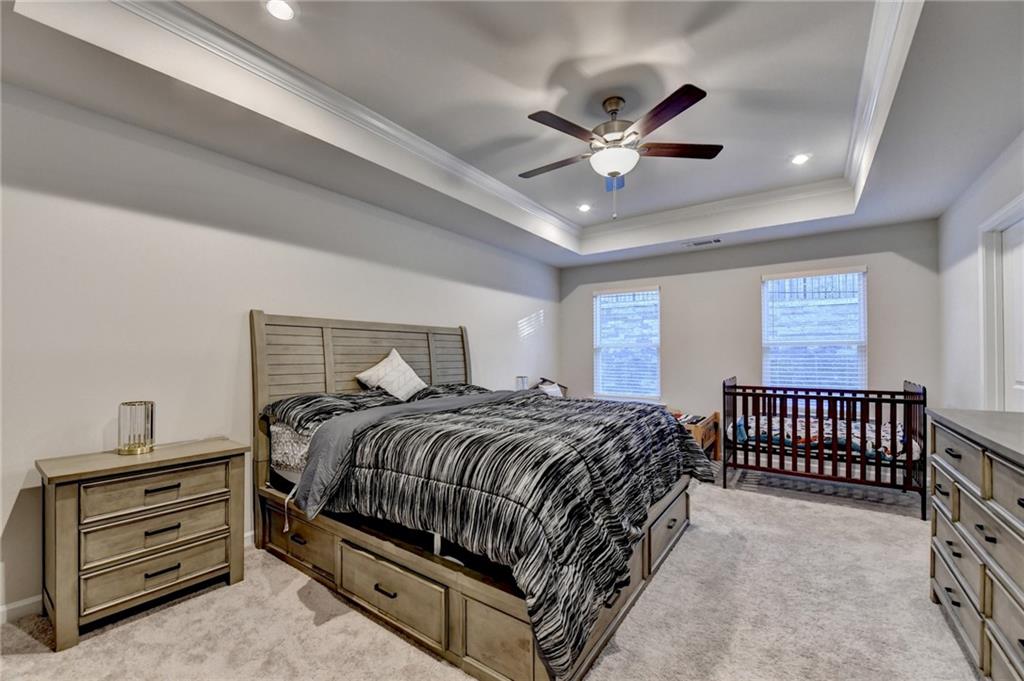 682 Smokey Quartz Way Kennesaw, GA 30144 - Photo 27 of 49 a bedroom with a bed and a chandelier