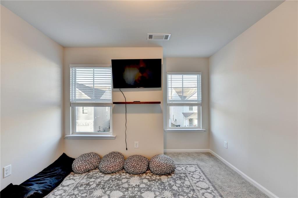 682 Smokey Quartz Way Kennesaw, GA 30144 - Photo 44 of 49 a bedroom with a bed and a flat screen tv