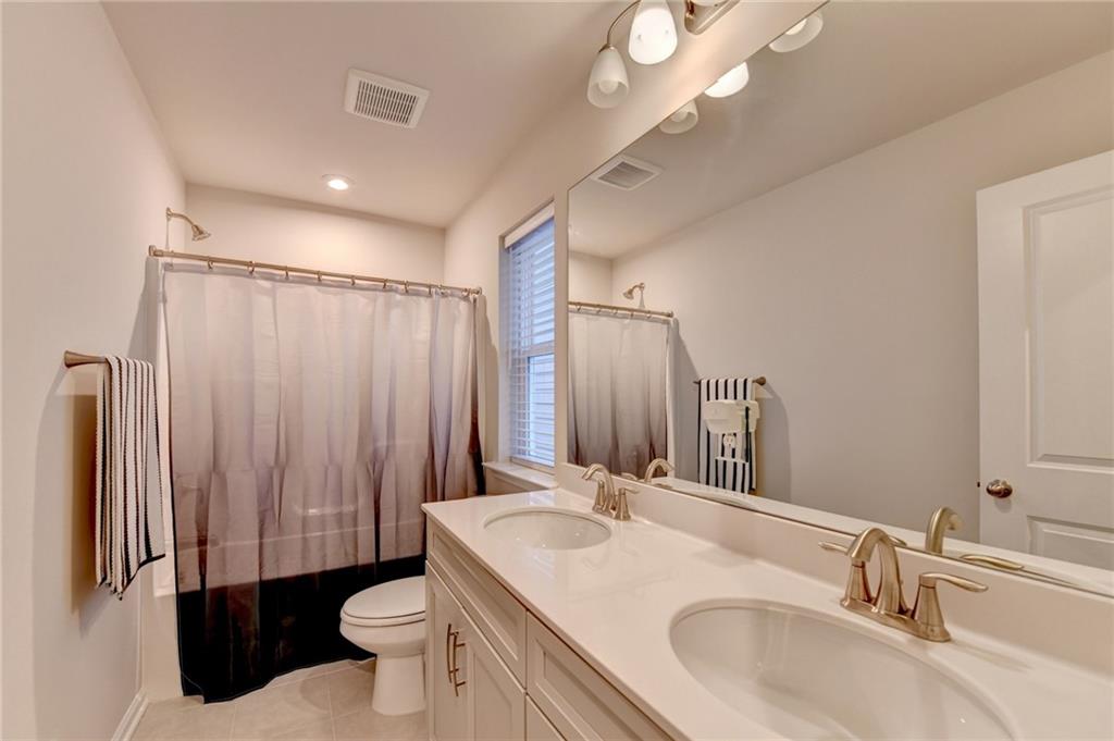 682 Smokey Quartz Way Kennesaw, GA 30144 - Photo 46 of 49 a bathroom with a sink toilet double vanity and shower