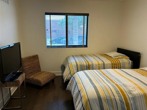 a bedroom with two beds and a chair