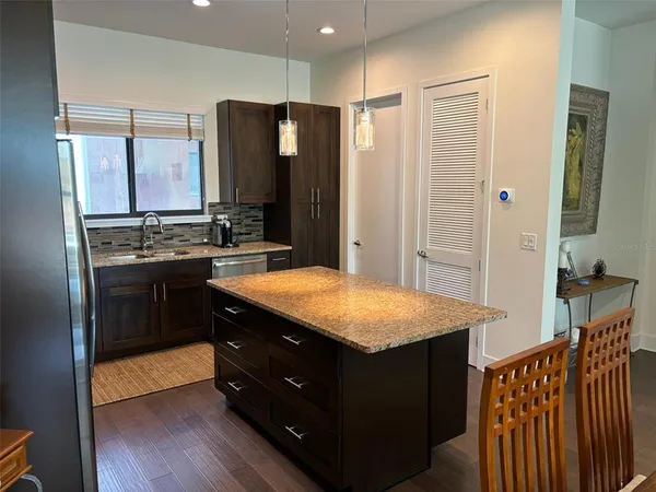a kitchen with stainless steel appliances granite countertop a stove a refrigerator and a sink