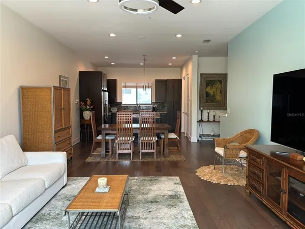 a living room with furniture wooden floor and a view of kitchen