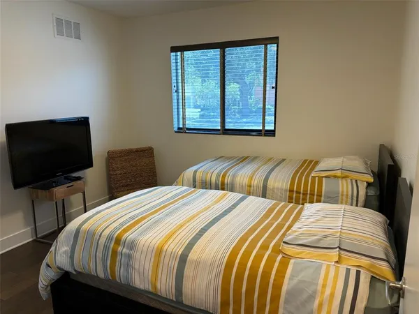 a bedroom with a bed and a flat screen tv