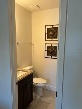 a bathroom with a granite countertop toilet and a sink