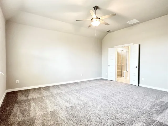 an empty room with a chandelier fan and windows