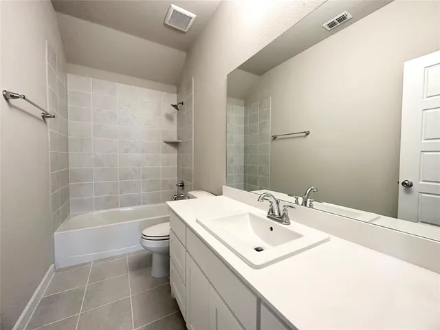 a bathroom with a sink mirror toilet and bathtub