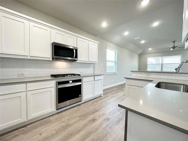 a kitchen with kitchen island white cabinets and stainless steel appliances