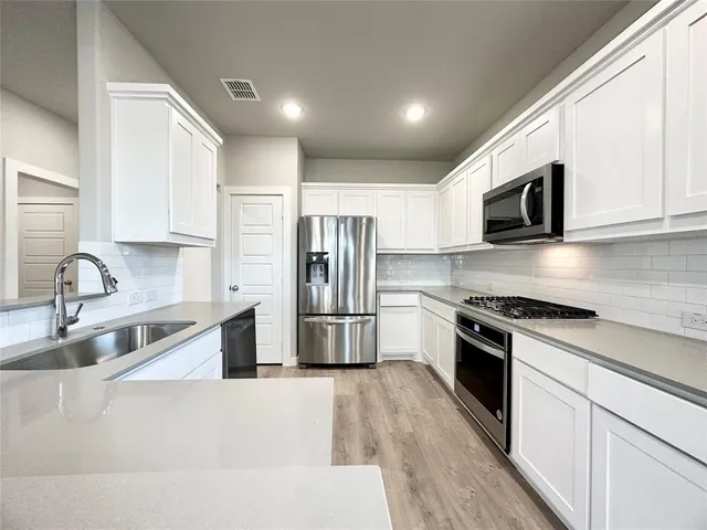 a kitchen with stainless steel appliances a stove sink microwave and refrigerator