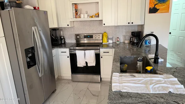 a kitchen with stainless steel appliances granite countertop a refrigerator and a sink